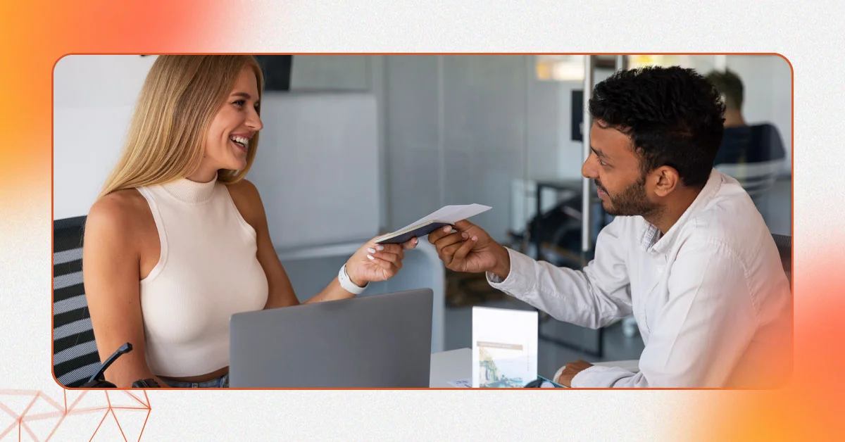 A woman and a man exchange documents across a desk, representing the seamless service provided by an ecommerce digital marketing agency offering comprehensive ecommerce digital marketing services for global brands.